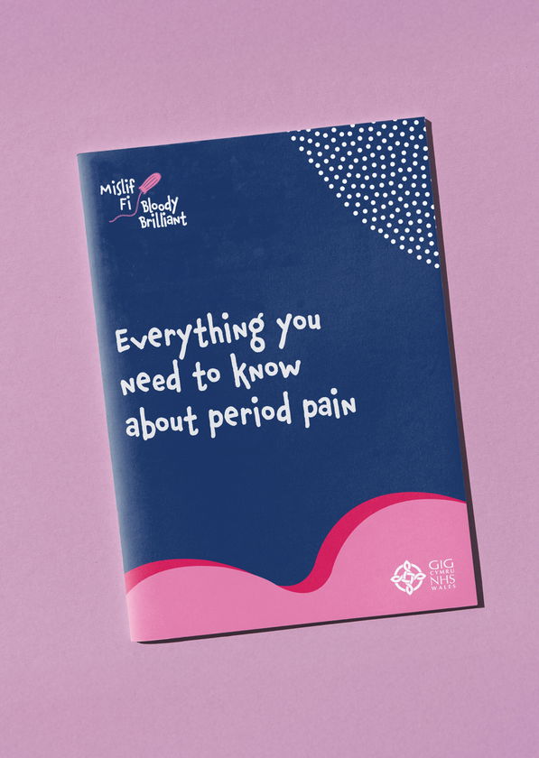 A booklet titled Everything you need to know about period pain with a navy blue and pink cover, lying on a pink surface. The cover includes logos for Bloody Brilliant and NHS Wales.