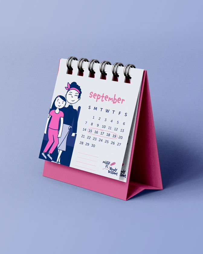 A desk calendar displaying the month of September with illustrated figures of a smiling man and woman beside the dates. The calendar has a pink stand and a purple background.