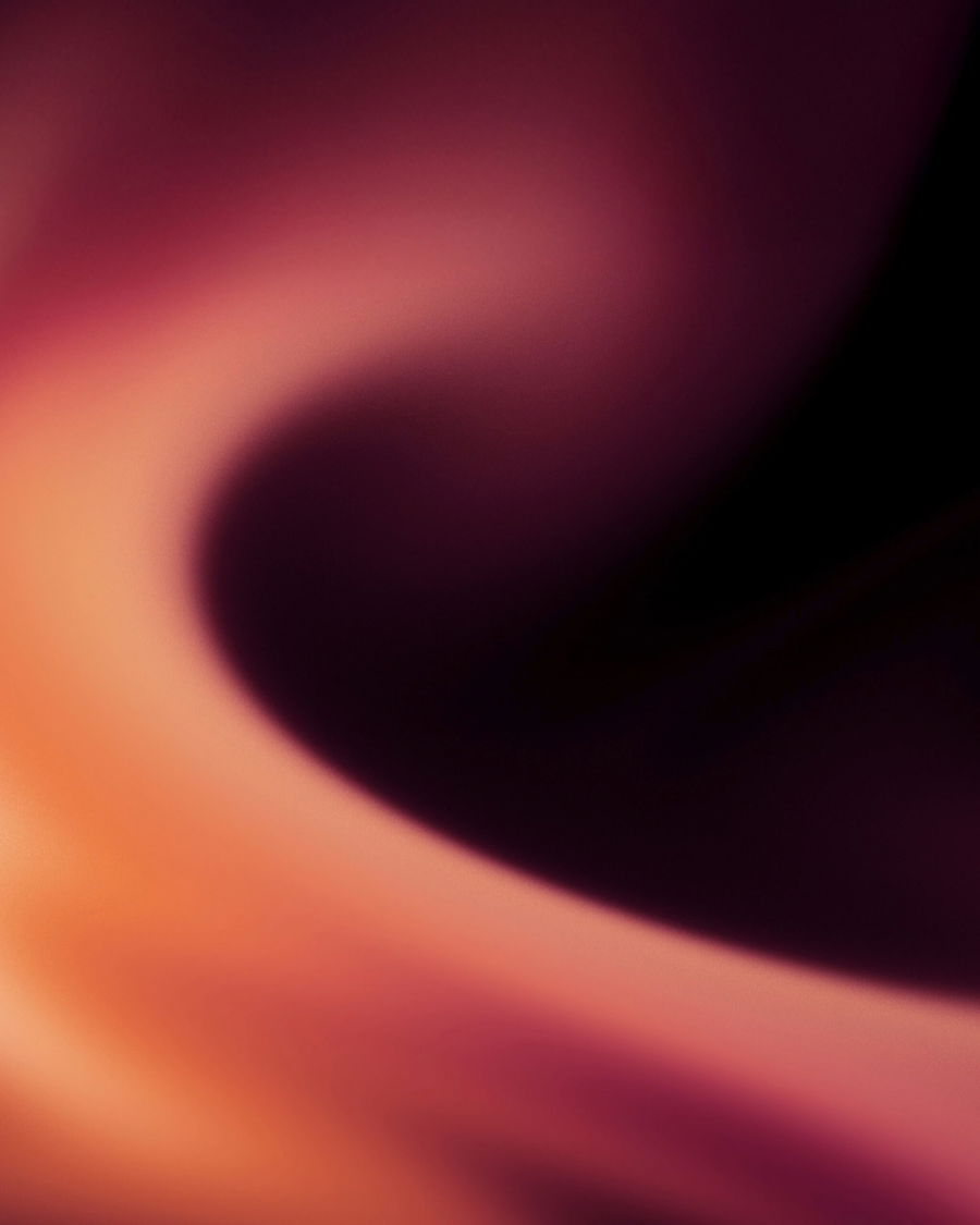 Abstract image with swirling shades of orange, red, and purple, blending smoothly to create a sense of motion and depth—a soft, glowing wave reminiscent of the energy behind the Glow For Good programme.