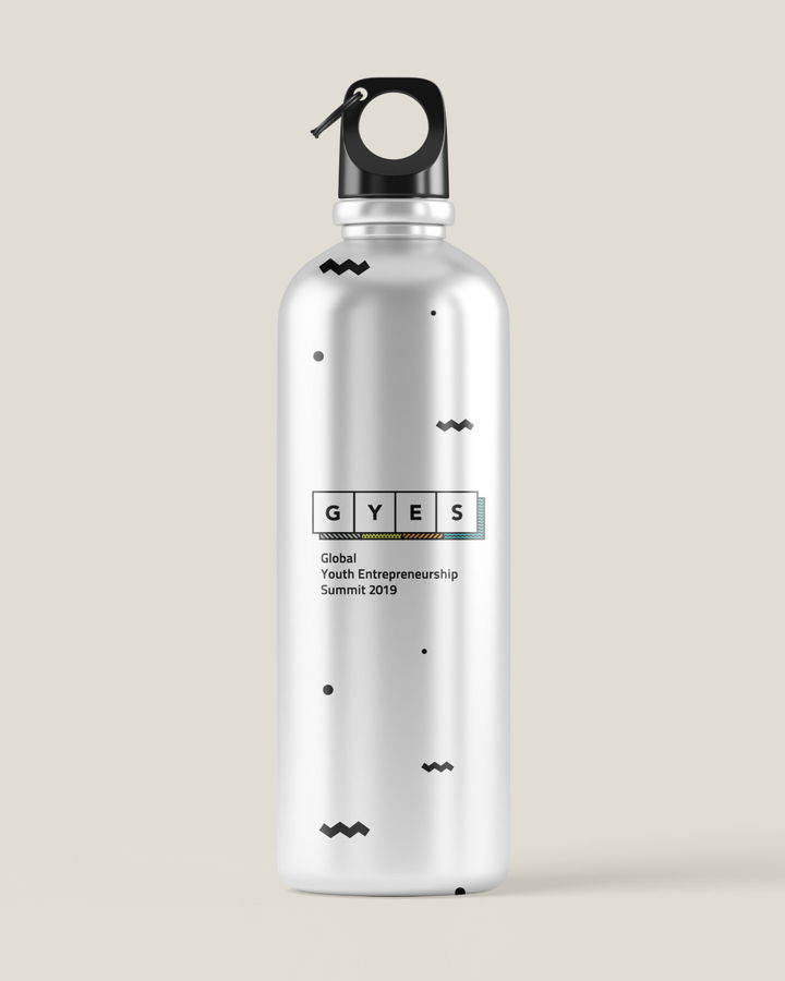 A silver reusable water bottle with a black cap and geometric patterns, featuring a label that reads GYES Global Youth Entrepreneurship Summit 2019.