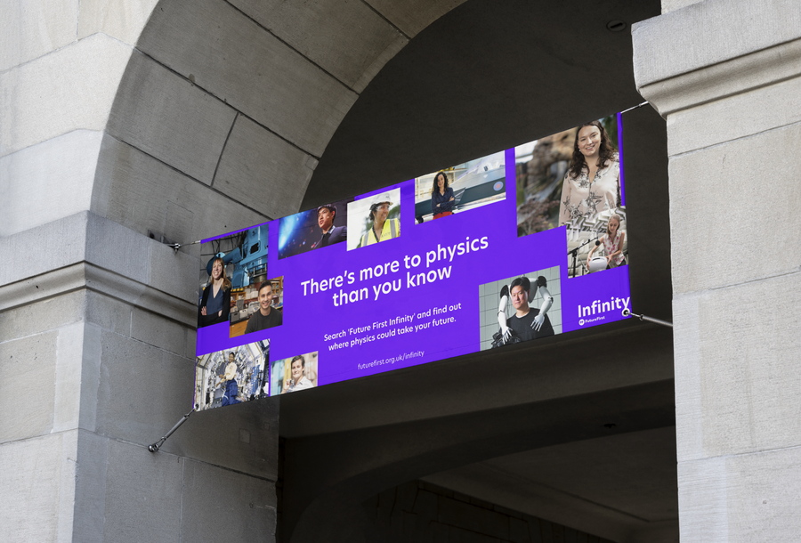 A rectangular banner hangs under an archway, featuring the text “There’s more to physics than you know” with photos of diverse people on a purple background. The banner promotes Infinity, a physics organisation.