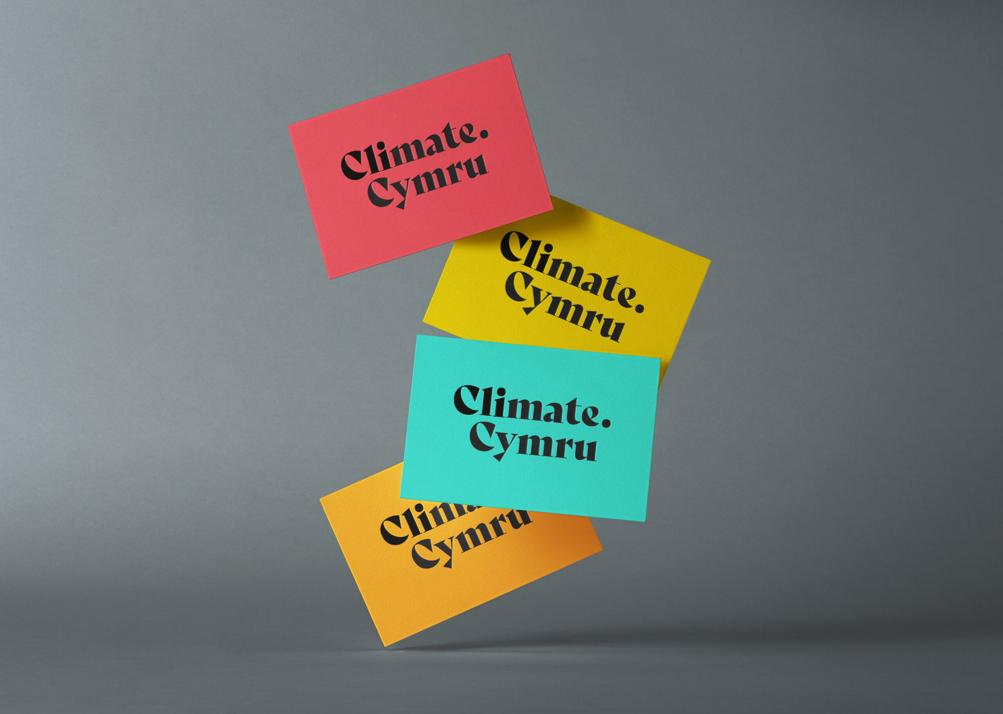 Four colourful cards (red, yellow, teal, orange) with the black text Climate. Cymru are floating against a grey background.
