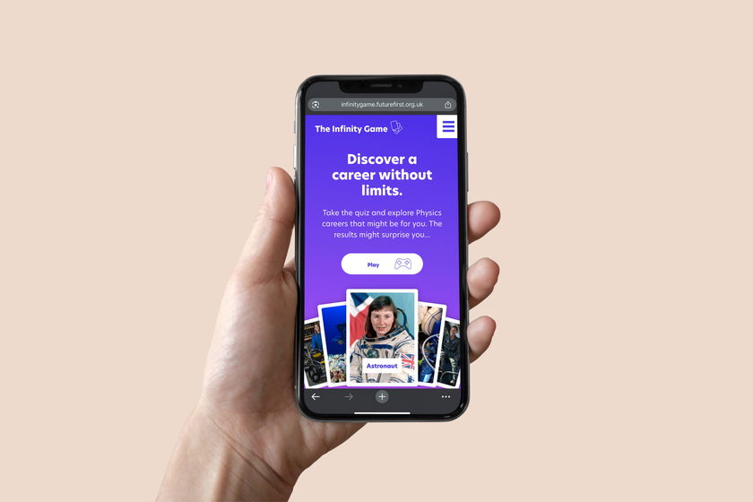 A hand holds a mobile phone displaying a website with a purple background that reads, Discover a career without limits, alongside images of astronauts and scientific themes.